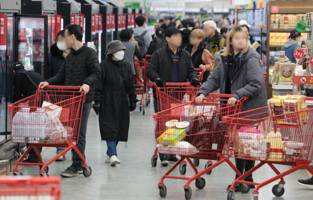 라면과 햄버거, 맥주, 커피, 빵, 초콜릿 등 가격이 품목과 기업을 가리지 않고 줄줄이 인상되고 있는 것으로 나타난 지난 3월 30일 서울 시내의 한 마트에서 시민들이 장을 보고 있다. 최근 달러 강세와 비상계엄 여파, 원재료 등 각종 비용이 오르면서 가공식품과 외식 물가 지수 상승률이 곧 3%를 웃돌 수 있다는 우려가 나오고 있다. [연합뉴스]